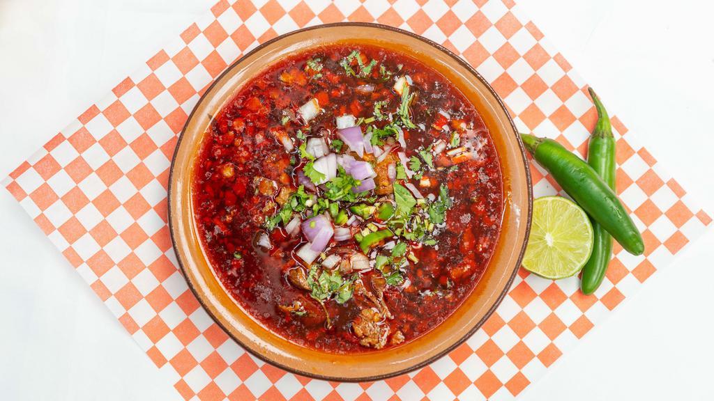 Berrian de res · Birria de Res (Beef Birria), is cooked in a broth that is full of spices, flavorful, and comforting. It is topped with fresh chopped onion and cilantro, a spicy salsa of choice, and served with corn tortillas.