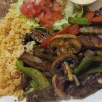 Fajitas Mix · Beef, chicken and shrimp cooked with bell peppers onions and mushrooms serve with a salad, r...