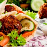 The Falafel Sandwich · Crispy garlic garbanzo beans marinated in homemade spices wrapped in a homemade pita.
