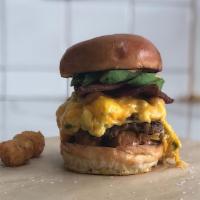 Broke Millionaire · Scrambled eggs, chives, caramelized onions, cheddar cheese, smashed tots, house made pork sa...