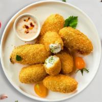 Caliente Poppers · Fresh jalapenos coated in potatoes, filled with cheddar cheese, and fried until golden brown...