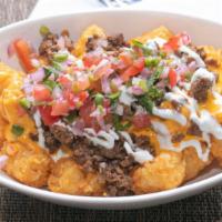 Asada Totchos · Crispy tater tots topped with nacho cheese, pico de gallo, sour cream, and grilled carne asa...