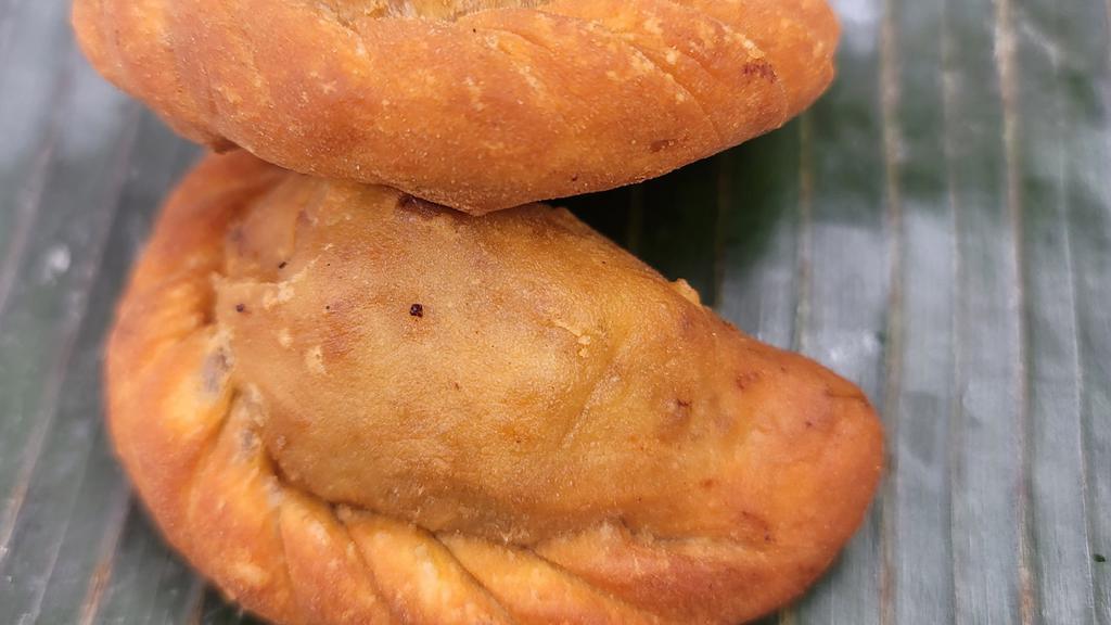 Empanada · 2 pieces of fried pastry with raisins and vegetable filling with choice of ground chicken or  ground beef with ground pork