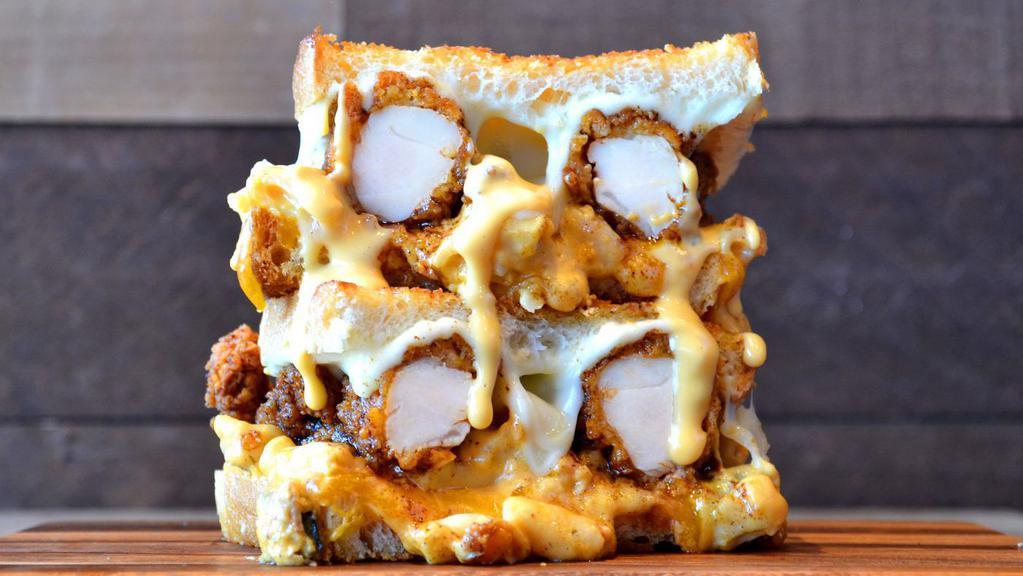 Nashville Hot Chicken Grilled Cheese · Crispy Nashville hot chicken tenders, and mac and cheese topped with cheddar and provolone cheese served on Parmesan sourdough.
