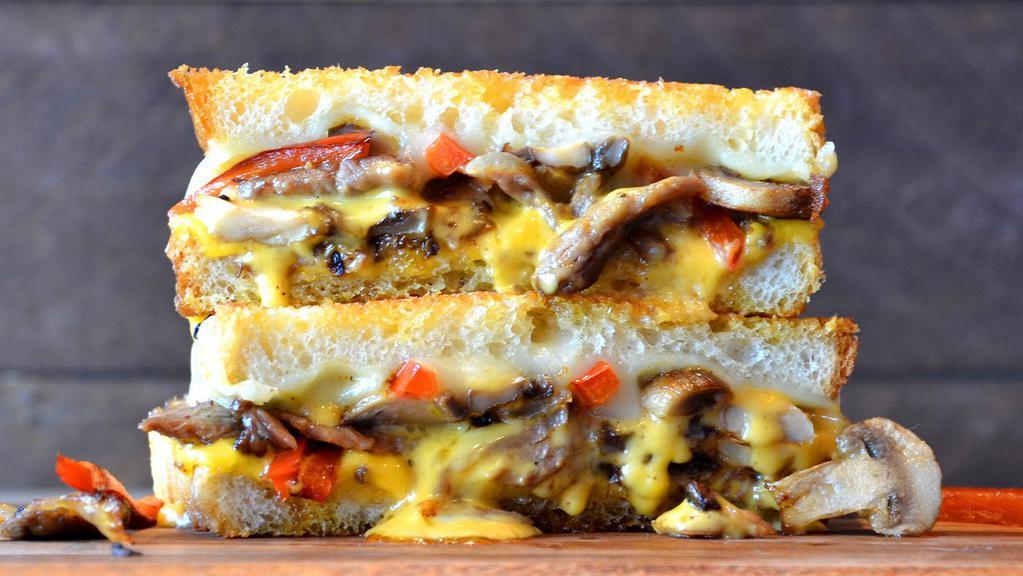 The Philly Grilled Cheese · Sliced sirloin, mushrooms, red peppers, caramelized onions, provolone and American cheese on Parmesan sourdough.