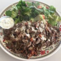 19. Beef Shawarma Plate · Slices of beef shawarma grilled with tomatoes served with tahini sauce, rice pilaf, salad, a...