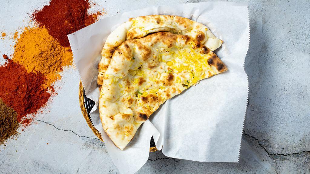 Garlic Naan · Freshly baked bread in a clay oven garnished with garlic and butter - talk about getting' fresh!