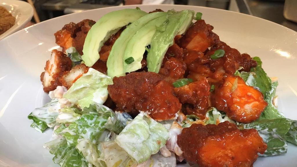 Buffalo Chicken Salad. · crispy chicken tossed in Frank’s hot sauce, romaine, chopped tomatoes, cheddar cheese, black beans, roasted corn, green onions, avocado, ranch dressing