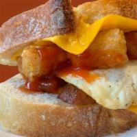 The Classic · Scrambled or over medium egg, applewood smoked bacon or sausage, crispy tots, American chees...