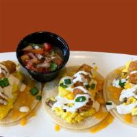 Taco Trio · three breakfast tacos filled with scrambled eggs, crispy tots, sausage, cheddar, cilantro cr...