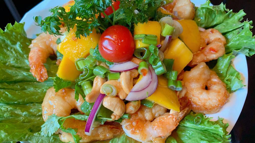 A05. Mango Shrimp Salad · Fried shrimp, mango, cashew nut, onions in spicy lime dressing, served with sliced cabbage.