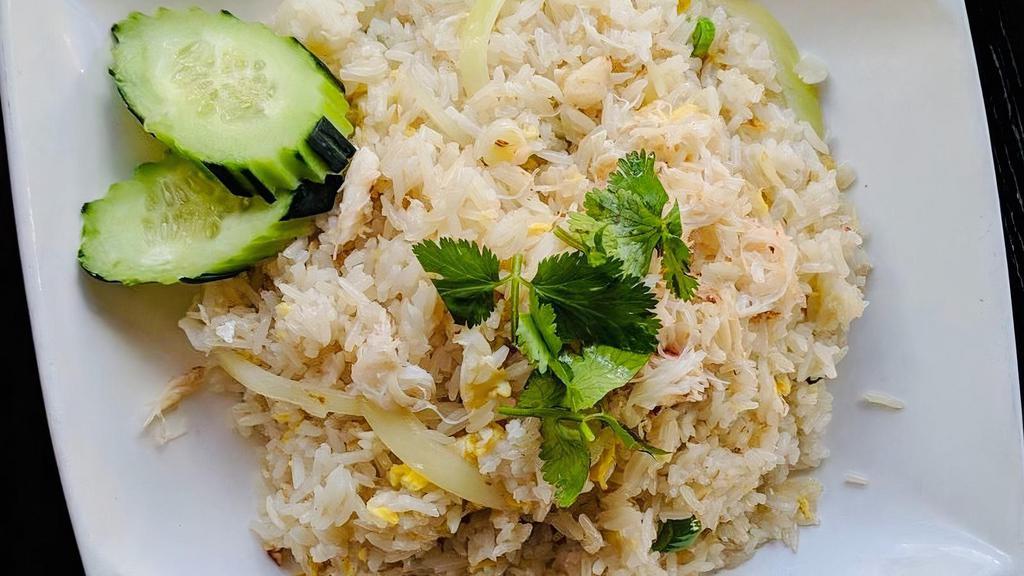 E03. Crab Meat Fried Rice · Fried rice with white crab meat, egg, white onion, and green onion topped with cilantro and cucumber.
