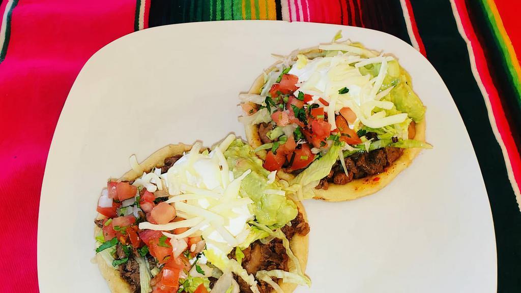 Sope (Single Sope) · Deep fried masa base topped with refried beans, your choice of meat, lettuce, pico de gallo, guacamole, cheese, and sour cream