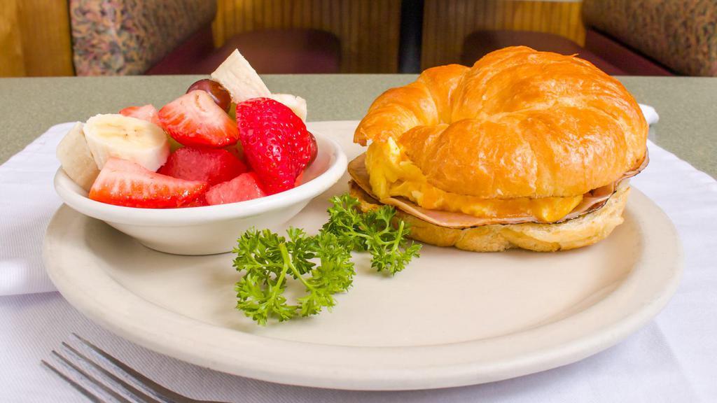 Croissant Breakfast Sandwich · Cal. 785-1198. Our award-winning items. Ham, or turkey, eggs, and cheese layered on a grilled croissant. Served with fruit or country potatoes.