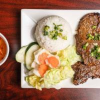 C2. Char-Broiled Pork Chop/CơM Sườn Heo Nướng · Served with fresh salad, tomatoes, cucumbers, and house vinaigrette and steamed rice.