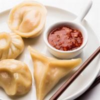 Chili Chicken Momo · Spicy! Classic chicken momo served on bed of sauteed bell peppers, onions and topped with ch...