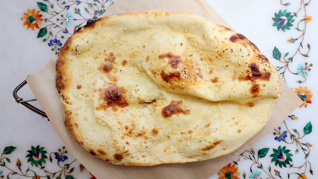 Garlic Naan · Tandoor baked white flour bread garnished with freshly minced garlic.