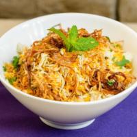 Chicken Biryani · Saffron flavored basmati rice with spiced chicken and nuts, served in handi.