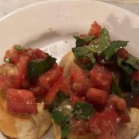 Bruschetta · Oven toasted bread topped with garlic, olive oil, tomatoes, and fresh basil.