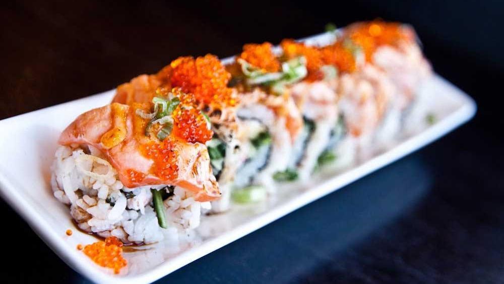 Pink Dragon Roll · Toasted salmon over crab salad and avocado with tobiko, green onion, spicy mayo, and eel sauce.