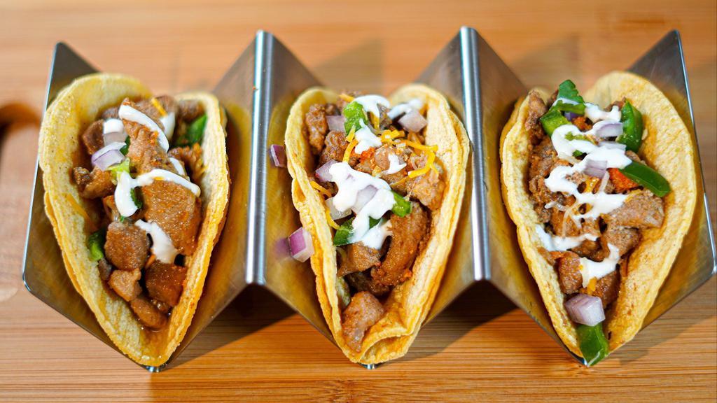 Sisig Tacos · Savory grilled pork topped off with onions, jalapeño, sour cream and chicharron.