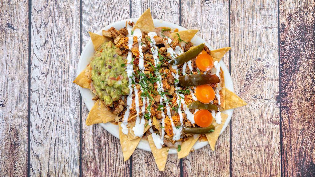 Super Nachos · Choice of meat, cheese, refried beans, sour cream, guacamole, jalapeños, and cilantro garnish.
