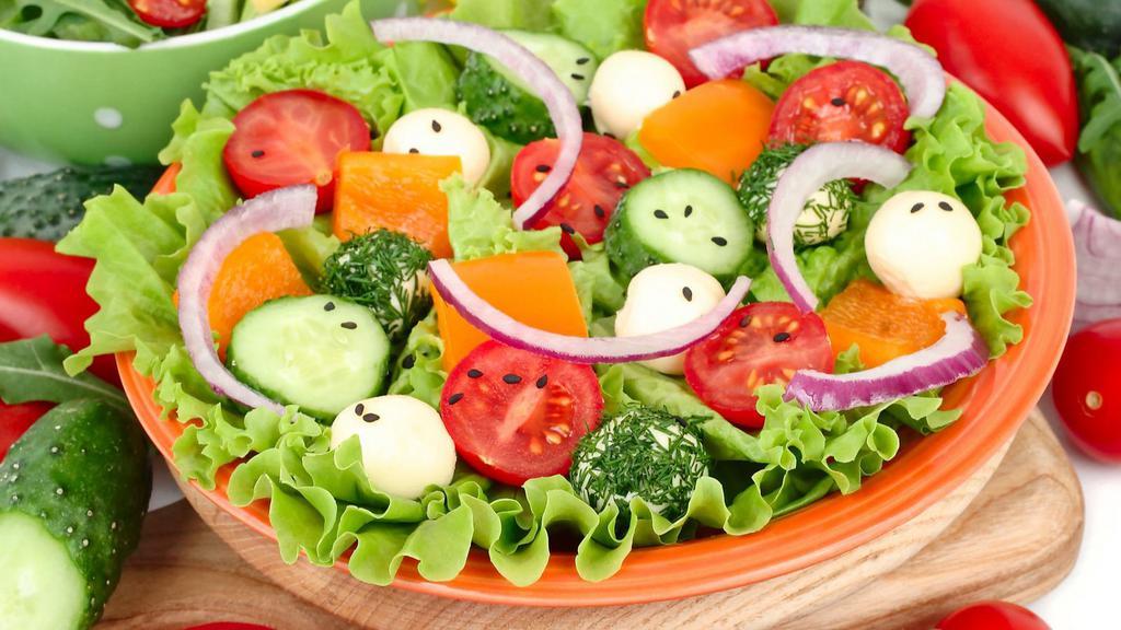House Garden Salad · Farmers market tomatoes and cucumbers over a bed of fresh lettuce, and topped with savory olives with a choice of dressing.