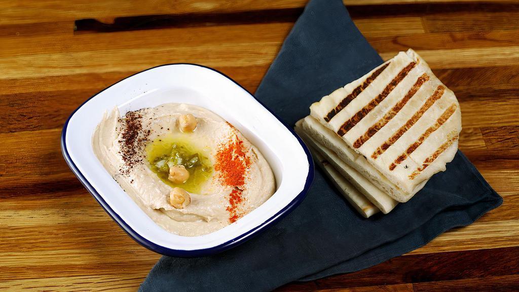 Classic Hummus · A delightful dip of garbanzo beans with garlic, lemon juice, tahini & olive oil. Served with pita bread.