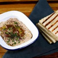 Babaganush · Roasted smoky eggplant with garlic, tahini & extra virgin olive oil. Served with pita bread.