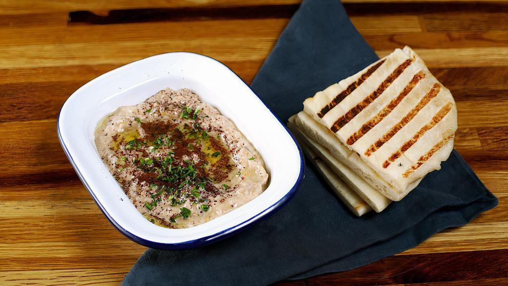 Babaganush · Roasted smoky eggplant with garlic, tahini & extra virgin olive oil. Served with pita bread.