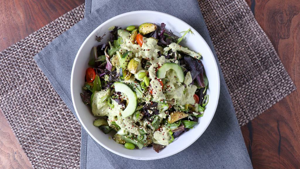 Green Goddess · Lettuce blend, edamame, roasted brussels sprouts, cherry tomato, scallions, cucumber, crushed almonds with a cashew-based green goddess dressing, garnished with toasted quinoa.