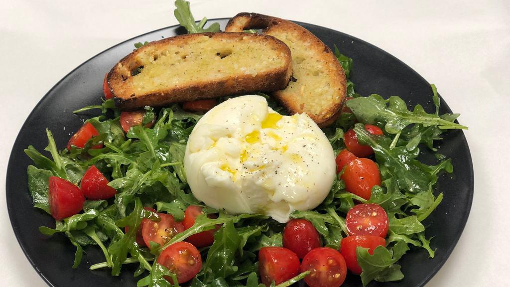 Burrata · Burrata cheese differs from the common mozzarella for it’s unique creamy heart. We serve it on a very simple arugula bed with cherry tomatoes and garlic bread. A tasty burrata doesn’t need much more.