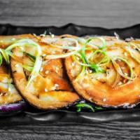 Grilled Chashu Plate · Grilled chashu with purple onion pickles, green onion, sesame seeds, and savory sauce.