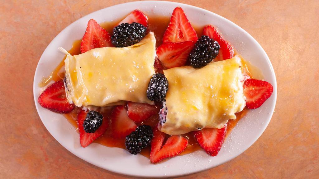 Crepes Berries · Warm crepes filled with whipped cream, seasonal berries, and Grand Marnier sauce.
