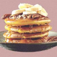 Banana Nut Pannies · 2 banana pancakes served with maple syrup, banana slices, toasted pecans, butter, and dusted...