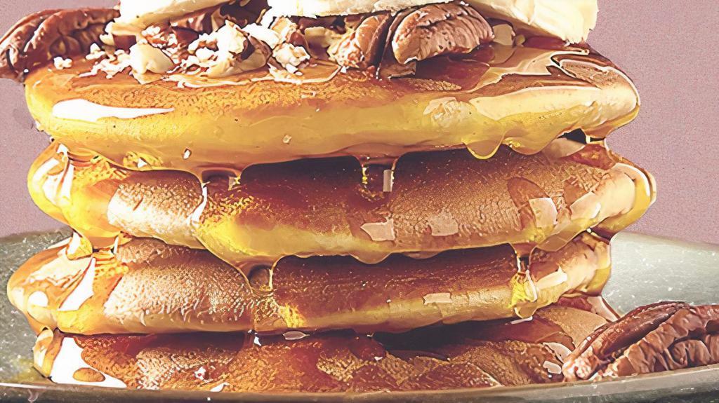 Banana Pannies · 2 banana pancakes served with maple syrup, banana slices, butter, and dusted with powdered sugar.
