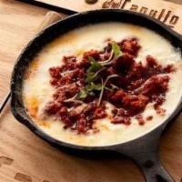 Queso Fundido · Melted oaxacan cheese topped with chorizo served with corn tortillas.