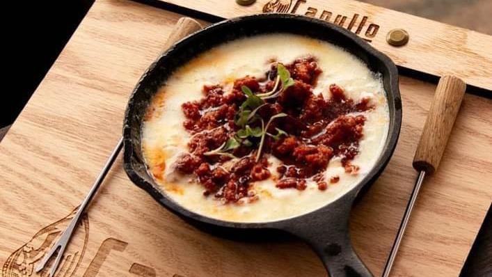 Queso Fundido · Melted oaxacan cheese topped with chorizo served with corn tortillas.
