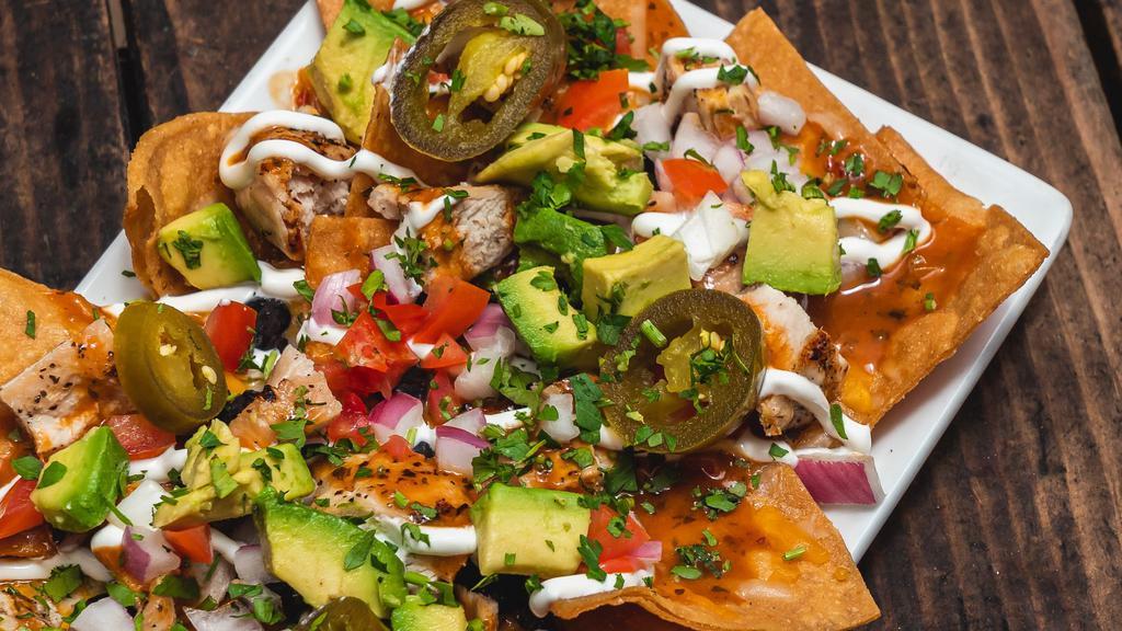 Grilled Chicken Nachos · Black beans / avocado / tomatoes / cilantro /red onions / cheese blend / jalapeños red onions / cheese blend / jalapeños / chipotle sauce / crema