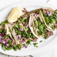 Tacos De Plazas · Choice of meat, onions, cilantro, and salsa de tomatillo.
