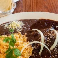 Mole Poblano · Tender boneless breast of chicken, smothered in a rich dark sauce made of dried chiles, seed...