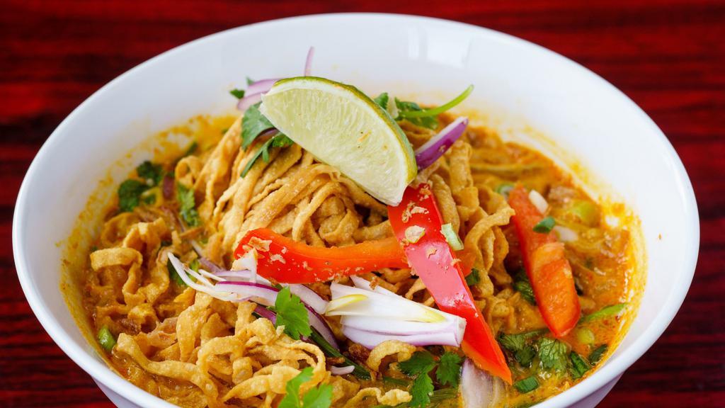 48. Chaing Mai Noodles (Kao Soy Thai) · Egg noodles served in light yellow curry soup with chicken, pickled mustard greens and red onions topped with fried egg noodle.