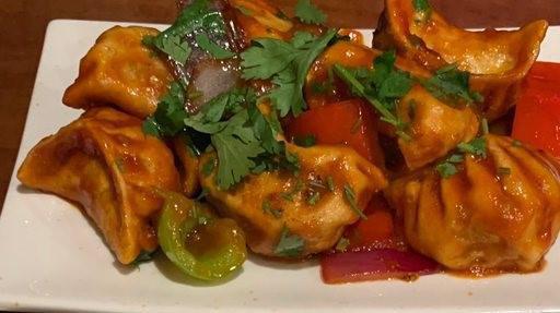 Chicken Chili Momo · Deep fried chicken momo mixed with onion gravy, tomato and chili.