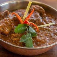 Goat Curry-Bone · Bone in goat cubes cooked with thick onion and tomato gravy sauce.