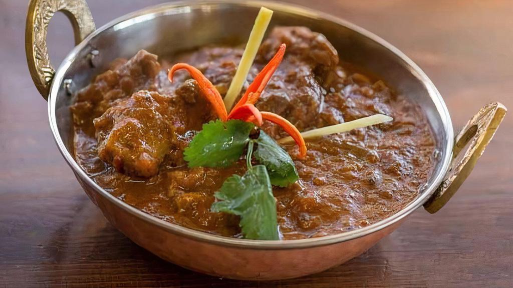 Goat Curry-Bone · Bone in goat cubes cooked with thick onion and tomato gravy sauce.