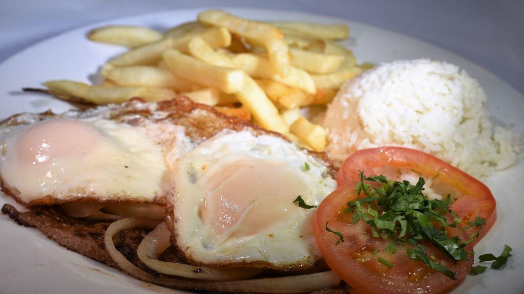 Bistec a Lo Pobre · Top sirloin Steak, 2 fried eggs on top, fried onions and French fries. Served with side of rice & a slice of tomato. Your choice of tortillas or toasted bread.