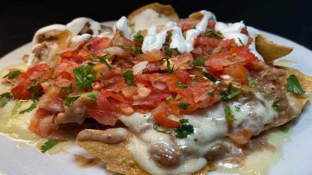 Regular Nachos · Homemade corn chips with melted Monterey jack cheese, mashed beans, salsa fresca and sour cream.