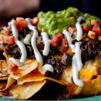 Supper Nachos · Tortilla chips overloaded with cheese, pico de gallo, pickled jalapeños, refried beans, sour...