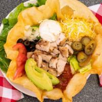 Taco Salad · Tortilla shell with your choice of chili, or chicken. Topped with avocado, shredded cheddar,...