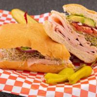 Turkeycado · Deli turkey, avocado, sweet red onion, sprouts and sliced tomato on a french roll.